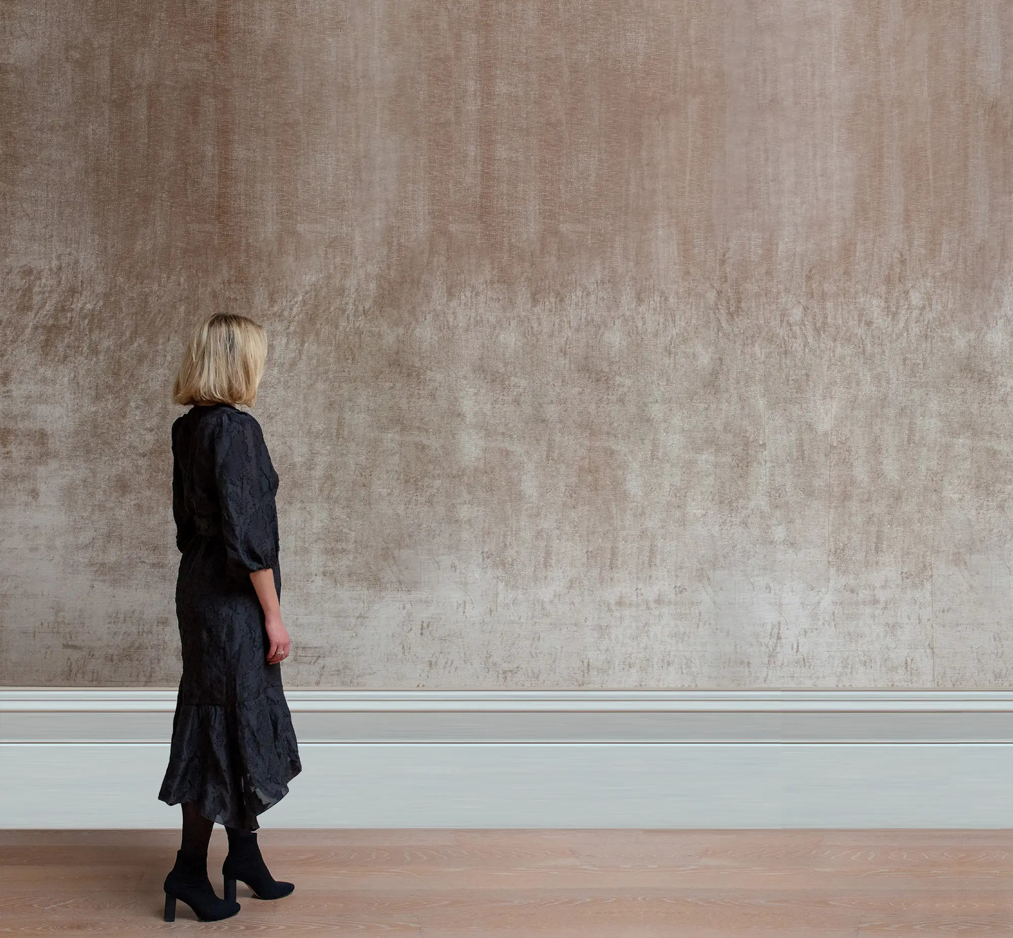 A photograph of a person facing a wall, to be overlaid with a scaled image of the artwork.